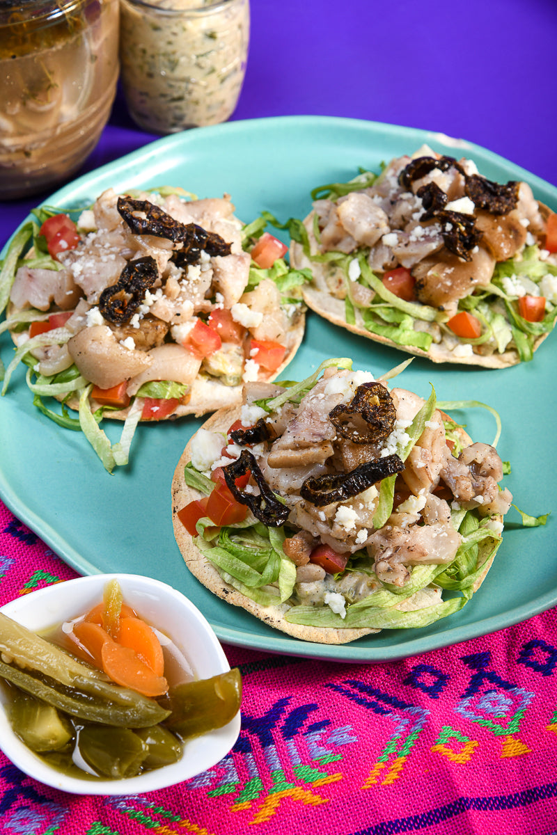 Tostada de patita de cerdo en escabeche con aderezo de chicharrón de jalapeño