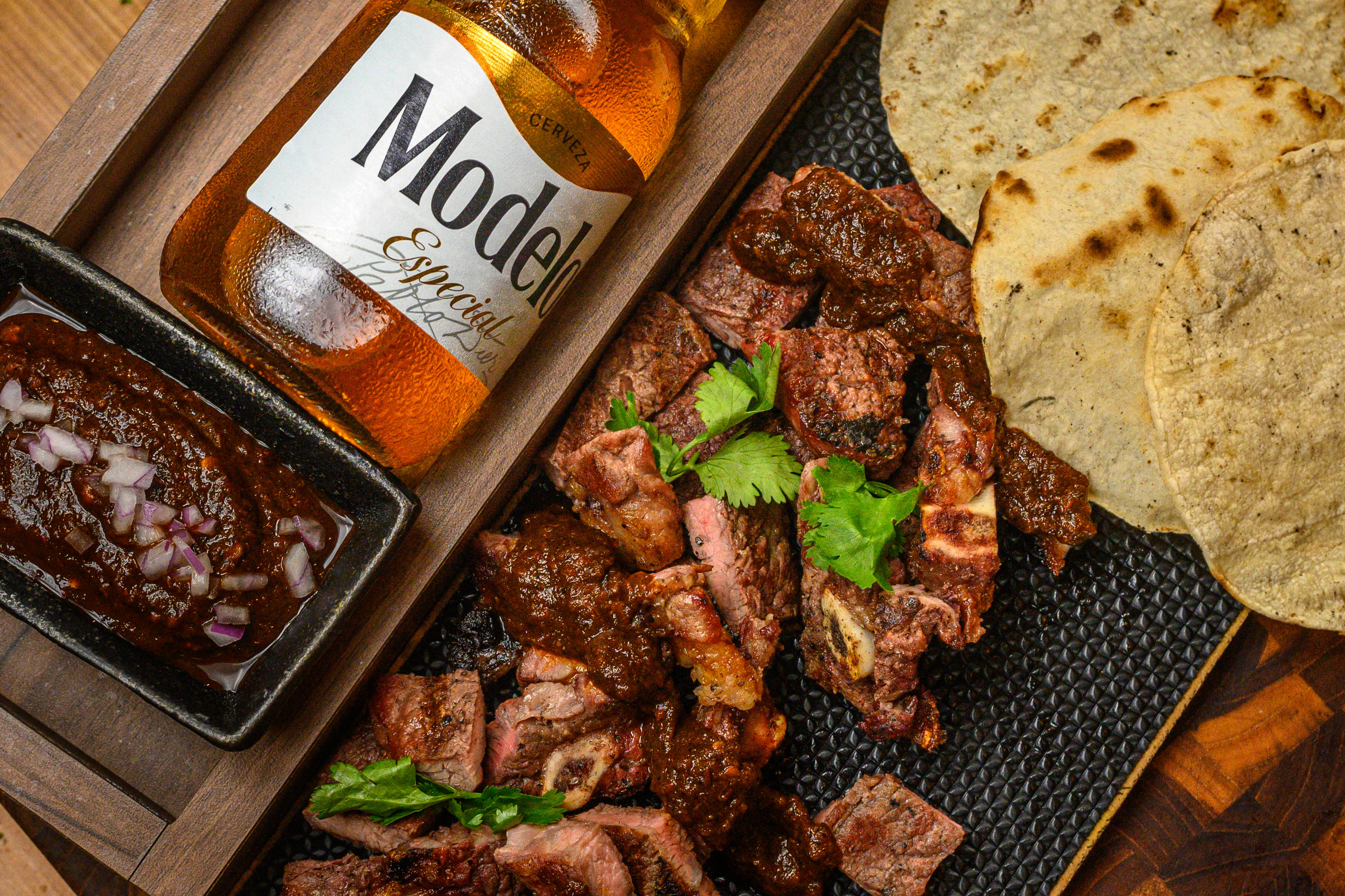 Tacos de costilla norteña con salsa de chile pasilla y Modelo Especial